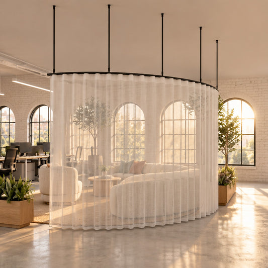 Zone A curved curtain track with a sheer wave curtain, suspended on drop tubes round a lounge beside an office walkway