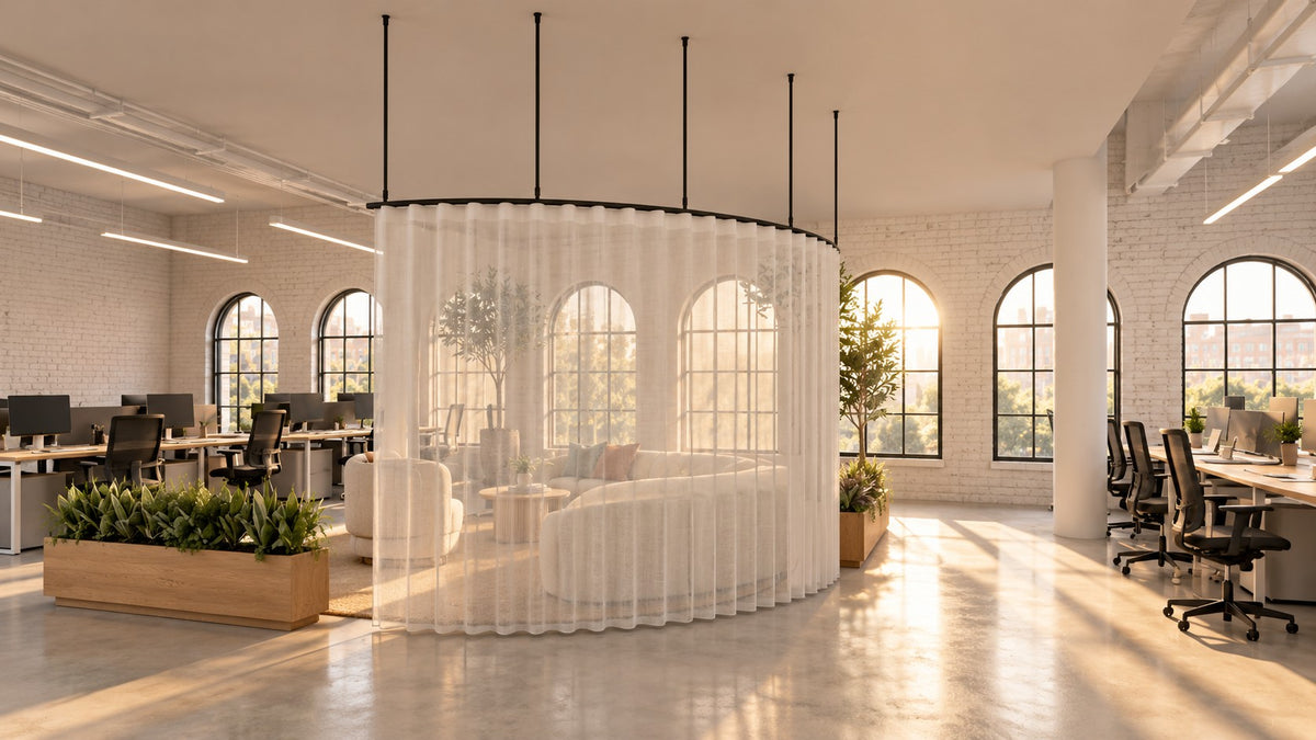 Zone A quarter arc curtain track with a sheer wave curtain screening a lounge from the walkway in an open-plan office